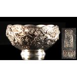 A Japanese silver bowl, Meiji period (1868-1912), decorated in high relief with a dragon among