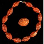 A Chinese carved coquilla nut necklace, the twelve beads modelled as Immortals, 19.3ins. (49cms.)