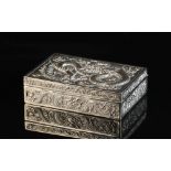 A Chinese silver rectangular cigarette box, early 20th century, decorated in relief with dragons,