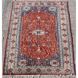 Property of a gentleman - a hand-knotted Turkoman design carpet, the central red field with navy