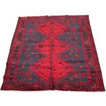 A Kordi woollen hand-made rug with claret ground, 100 by 64ins. (254 by 163cms.) (see