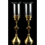 Property of a lady - a pair of brass Gothic style candlesticks, with ruby & clear glass bosses, with