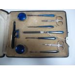 A Cased Manicure Set, highlighted in dark blue enamel, (scissors replaces).