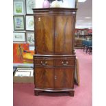 A Reproduction Mahogany Bow Fronted Cocktail Cabinet, having twin cupboard doors, flanking reeded