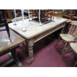 A Victorian Pine Kitchen Table, on ring turned tapering legs, brass castors (later replaced top),