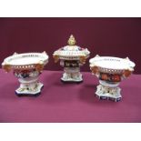 A Garniture of Three XIX Century Derby China Pot Pourri Pedestal Vases, one only with cover, painted