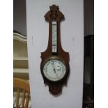 An Early XX Century Oak Cased Wall Barometer, with pierced decoration, finial to thermometer gauge