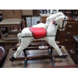 A XX Century White Dappled Rocking Horse, close studded red leather seat, standard base with tubular
