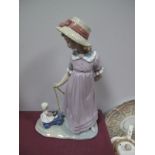 A Lladro Model of a Young Girl Wearing a Bonnet Pulling a Doll on a Kart, all on naturalistic