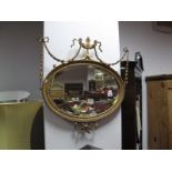 An Early XX Century Oval Bevelled Wall Mirror, in gilt Rococo style frame having applied vase,