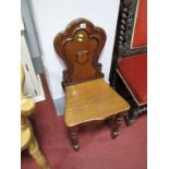 A Victorian Mahogany Hall Chair, shaped balloon back, with carved "C" scrolls and central shield