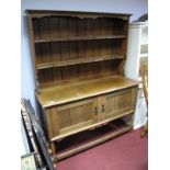 A XX Century Oak Dresser, the rack with a shaped frieze, two shelves, panelled back, base with two