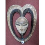 A Kota Kwele (Eastern Gabon) Carved and Painted Wood Mask, set within a heart shaped frame, late