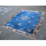 An Chinese Wool Carpet, circa 1920's with regal figure and floral motifs, on a deep blue ground