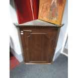 A Late XVIII Century Oak Planked Corner Cupboard, with dentil cornice, panelled door and two