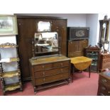 A 1920's Oak Three Piece Bedroom Suite, wardrobe, dressing table, chest of drawers, all with cup