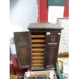 Early XX Century Oak Table Top Cabinet, with a sarcophagus top, carved panelled doors, with eight