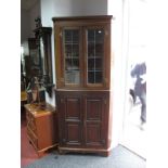 An Oak Two Section Freestanding Corner Cupboard, plain cornice over twin leaded glazed doors with