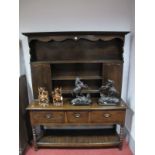 An XVIII Century Style Oak Dresser, the rack with a dentil cornice, shaped apron, three shelves,
