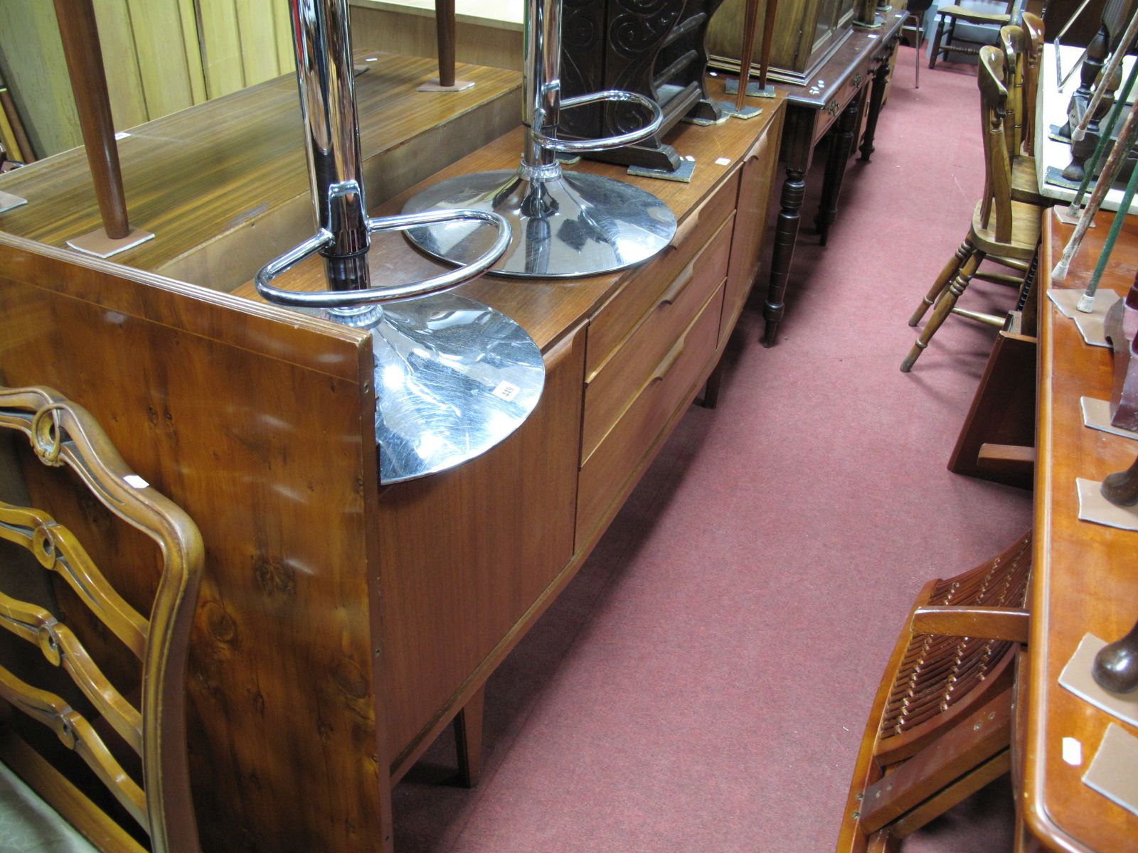 A 1960's Bow Fronted Teak Sideboard, having a bank of three central short drawers and flanking