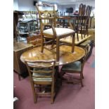 Yew Wood Oval Shaped Extending Dining Table, together with four ladder back dining chairs.
