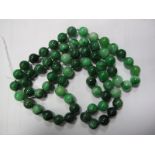 A Long Single Strand Polished Green Hardstone Bead Necklace, the uniform beads knotted.