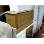 A Modern Joined Pine Blanket Box, with hinged top over panelled front on plinth base.