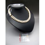 A Two Row Pearl Bead Necklace, the uniform beads knotted to 9ct gold flowerhead clasp.