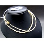 A Graduated Single Strand Pearl Bead Necklace, the beads knotted to panel clasp, stamped "9ct";