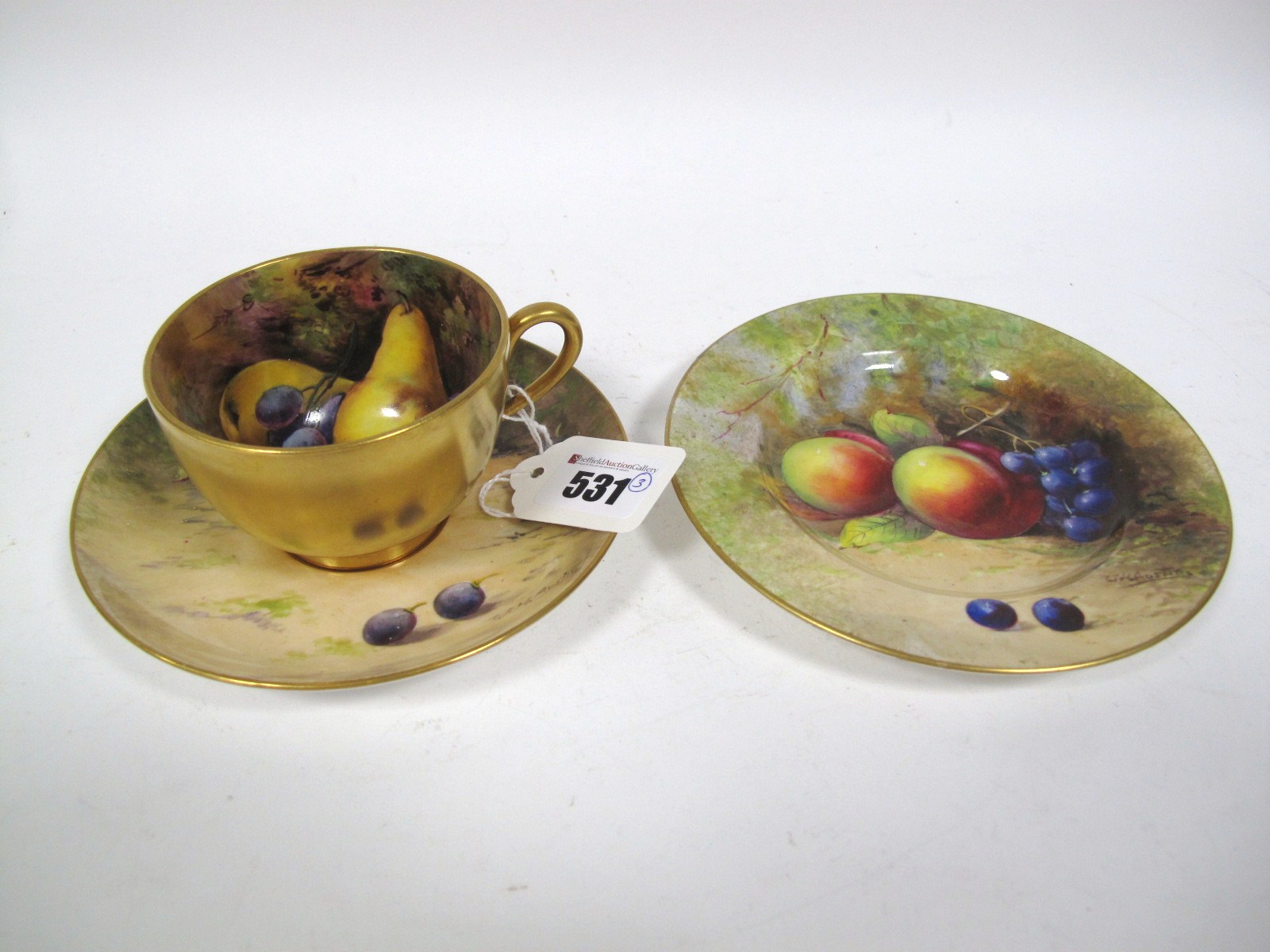 A Royal Worcester China Trio, painted and gilt with fruit on a naturalistic ground, signed W.H.