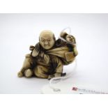 A Late XIX Century Japanese Ivory Netsuke, carved as a man with a sack containing an Oni on his