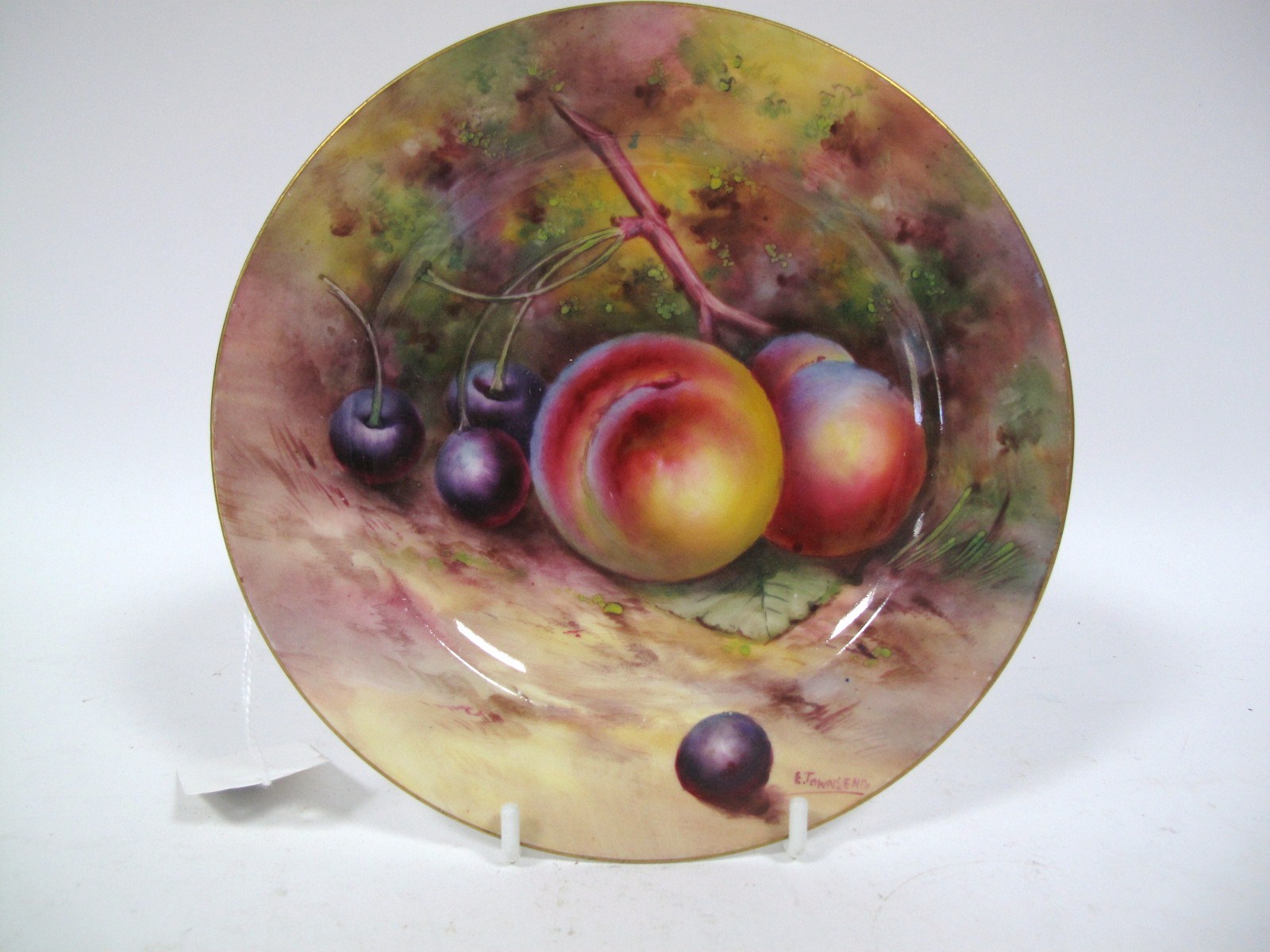 A Royal Worcester China Plate, painted and gilt with peaches and cherries on a naturalistic