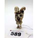 An Early XX Century Japanese Ivory Netsuke, carved as a standing man holding an animalistic bag