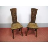 A Pair of Oak Chairs, the splats carved with a dragon and stag, adzed seats, segmented frieze, on