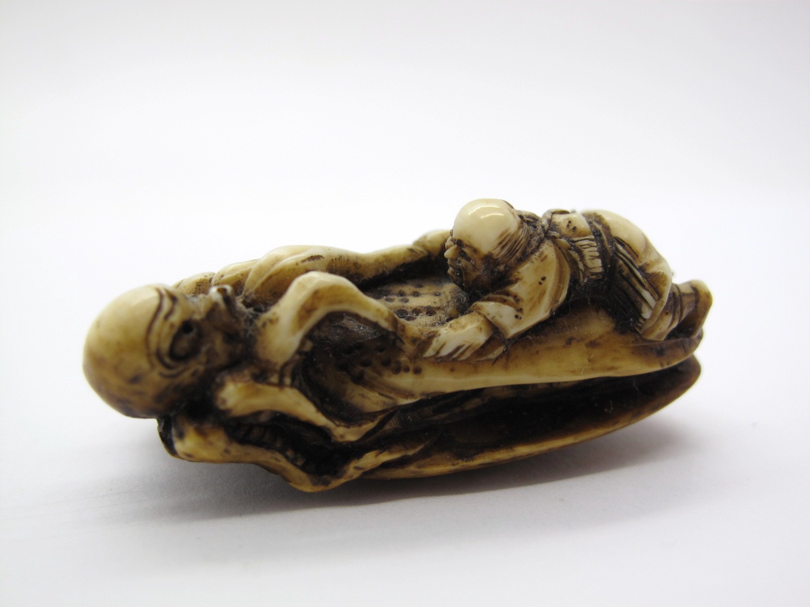 A Late XIX Century Japanese Ivory Netsuke, carved as a fisherman and an octopus on a clam shell, 4.