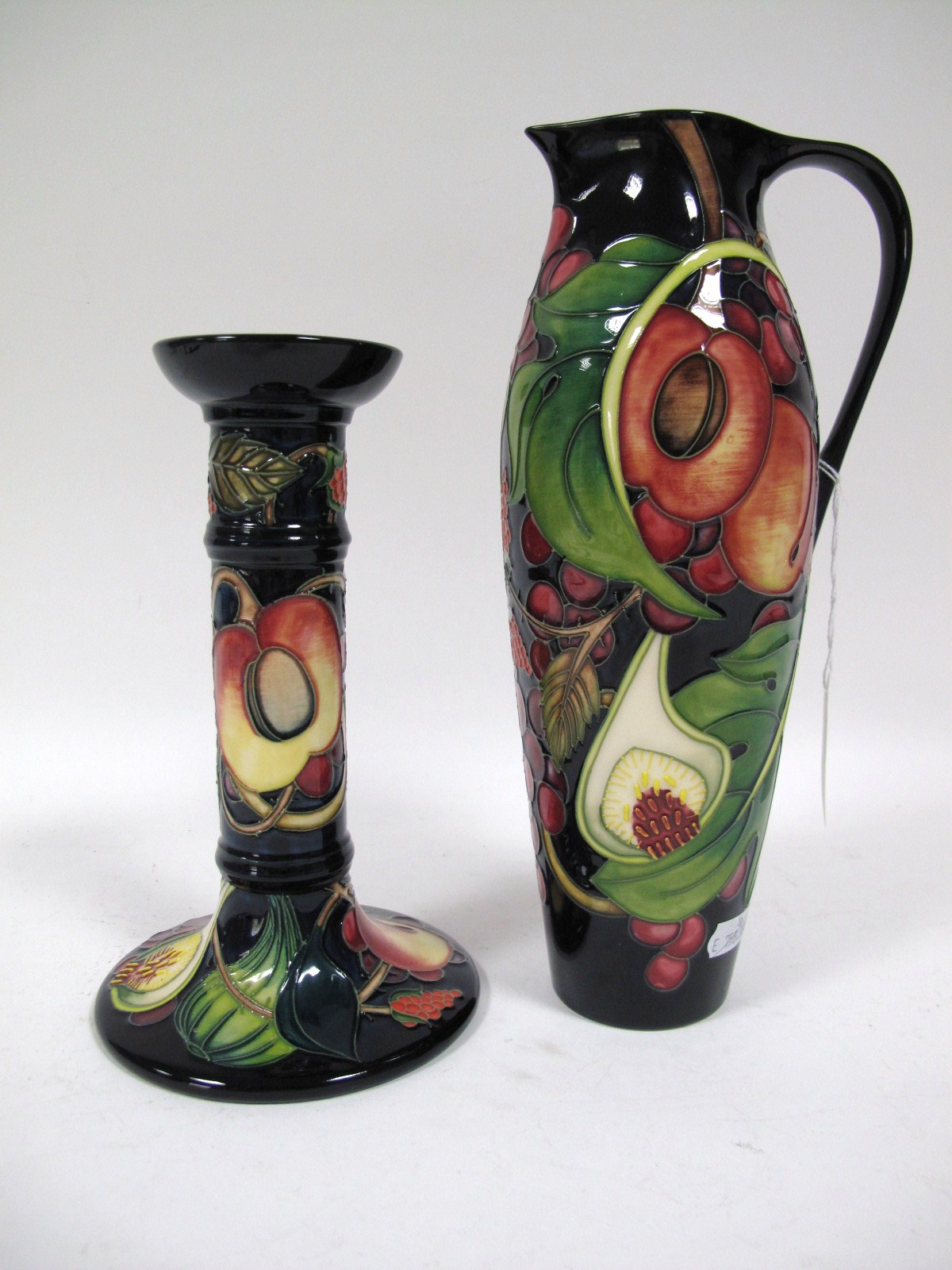 A Moorcroft Pottery Jug, of tall slender circular section, tube-lined and painted with fruit and