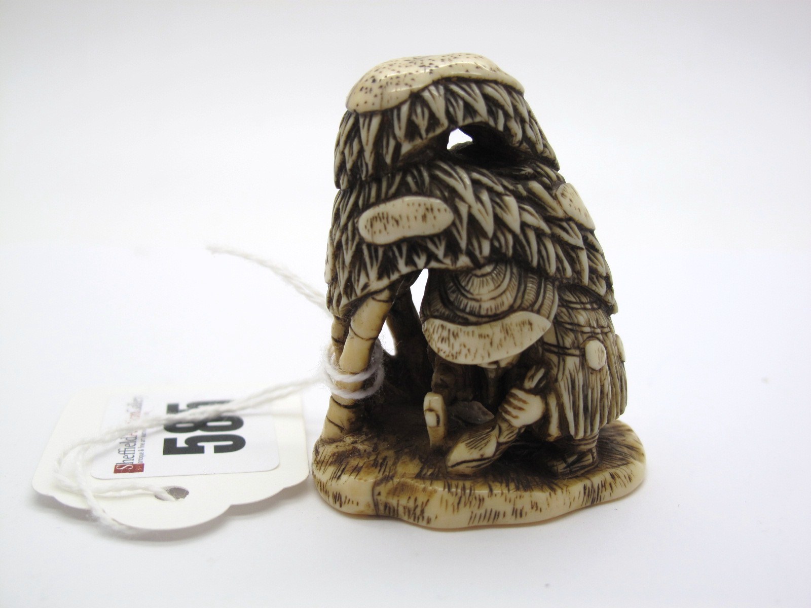 A XIX Century Japanese Ivory Netsuke, carved as a woodcutter working beneath a canopy of trees, 5.