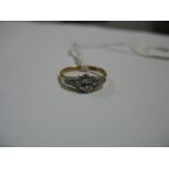 A Diamond Set Ring, circular collet set to the centre between shaped shoulders, stamped "18ct".