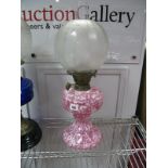 An Early XX Century Pink and White Mottled Glass Oil Lamp, with cameo frosted shade.