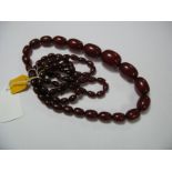 A Graduated Single Strand Amber Type Bead Necklace; together with a similar bracelet. (2)