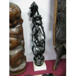 Ebonised African Carved Stylised Surmounted Figure Group, of open sinuous and grotesque form, on