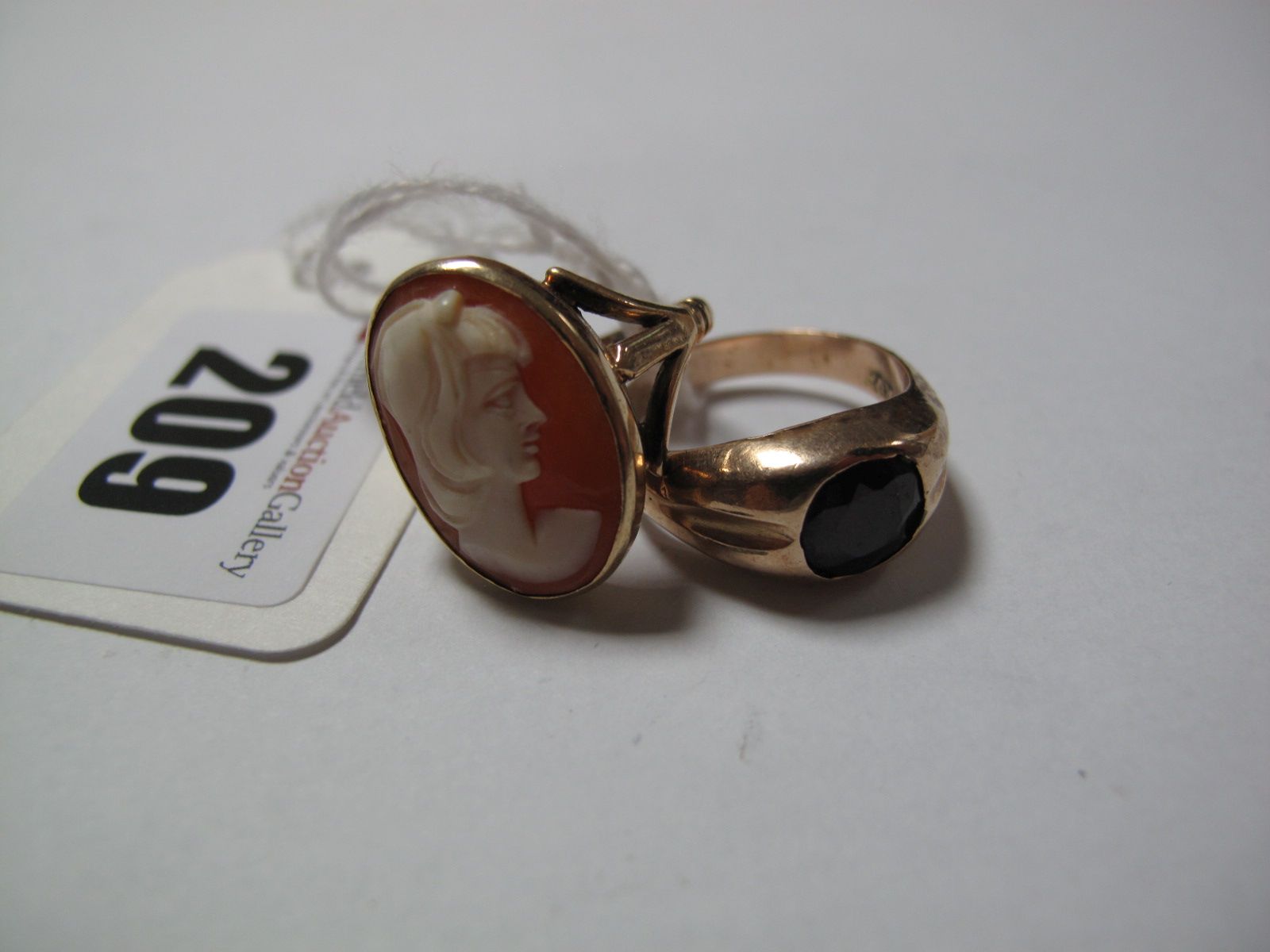 A 9ct Gold Single Stone Ring, rubover set; together with an oval cameo ring, stamped "9ct". (2)