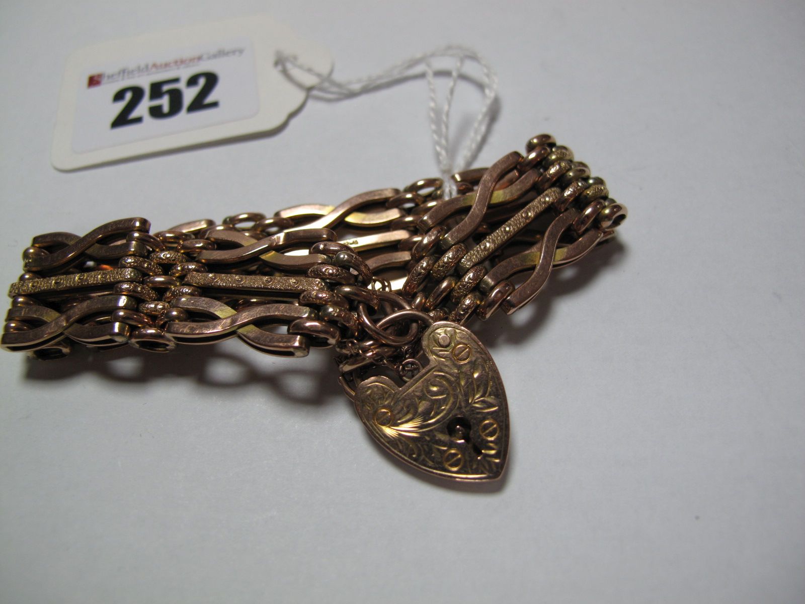 A Fancy Link Bracelet, indistinctly stamped "9ct", to heart shape padlock clasp, stamped "9ct gold".