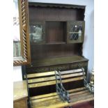 An Oak Wall Unit, with shaped apron piece over open shelves and twin leaded glazed doors, all