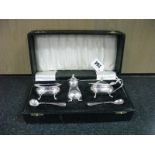 A Hallmarked Silver Three Piece Cruet Set, together with associated spoons, in a fitted case.