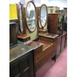 An Edwardian Inlaid Dressing Table, with a central oval mirror, side mirrors, jewel drawers over two