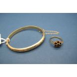 A 9ct Gold Child's Bangle, leaf scroll engraved to the front, hinged to snap clasp; Together with