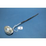 A Georgian Toddy Ladle, the oval bowl with inset coin and twisted handle, 37cms long.