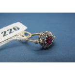 A Ruby(?) and Diamond Cluster Ring, claw set to the centre, within border of rose cut diamonds and