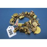 A Fancy Curb Link Bracelet, to heart shape padlock clasp, suspending numerous novelty charm